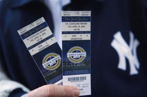 A Yankees fan shows his tickets to the first regular season MLB baseball game between the Yankees and the Indians at the new Yankee Stadium in New York